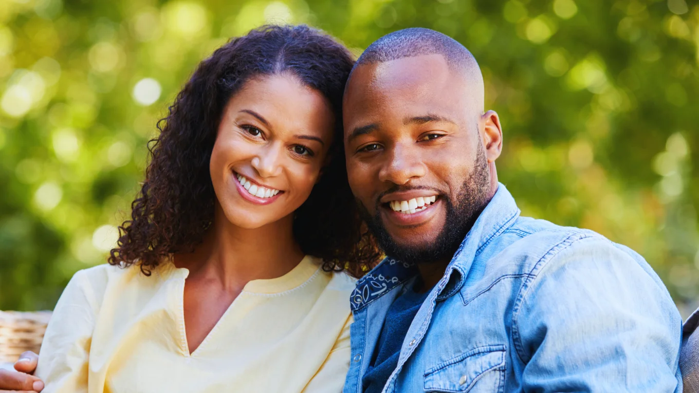 Smiling couple sitting close together outdoors