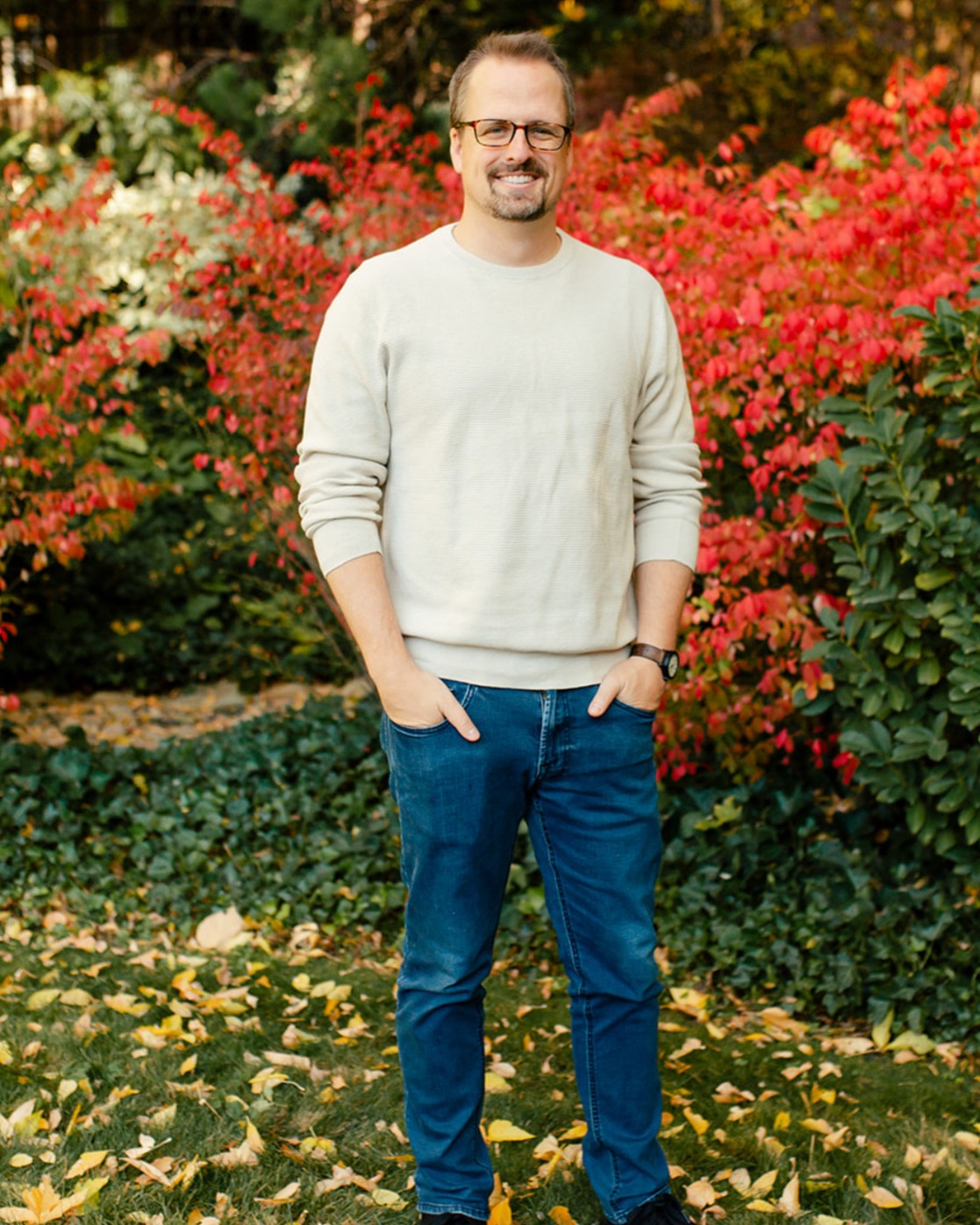Hugh Pinnock standing outdoors among autumn foliage